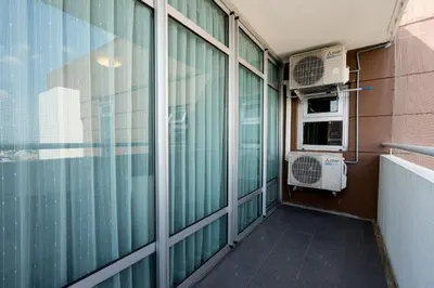 an empty balcony with a room with windows and an air conditioner at Spacious 3BR near Impact, Don Mueang Airport & Pink Line MRT in Nonthaburi