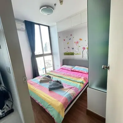 a bedroom with a bed with a colorful blanket at Sukhumvit Bts ideomix1 in Amphoe Phra Khanong