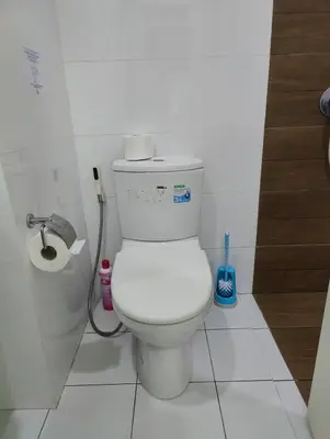 a white bathroom with a toilet and a shower at Cozy Apartment Night Market and Shopping Mall at MRT Purple Line in Nonthaburi