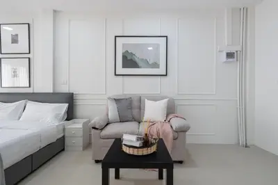 a bedroom with a bed and a chair and a table at Arun Sa wad - Chinatown in Bangkok