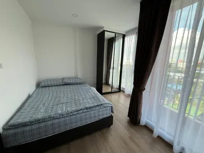 a bedroom with a bed and a large window at Cybiq Ratchada 32 By OBM in Ban Zong Katiam