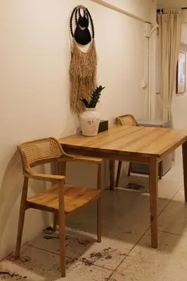 a wooden table with a bench and a hat on the wall at baan nuit Bangkok Stayhouse in Bangkok