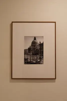 a framed picture of a building on a wall at baan nuit Bangkok Stayhouse in Bangkok