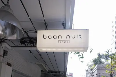 a sign hanging from the ceiling of a building at baan nuit Bangkok Stayhouse in Bangkok