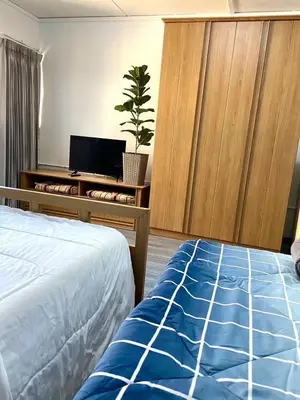 a bedroom with a bed and a dresser with a tv at Impact Arena C3 Twin Beds By GoodRoom 24 in Ban Bang Phang