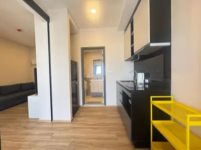 a kitchen with a black counter and yellow accents at Neon Cloud Bangkok in Bangkok