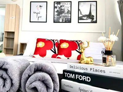 a bedroom with a bed with red pillows and a table with towels at Impact Arena Condo C7 fl12 By GoodRoom24 in Ban Song Hong