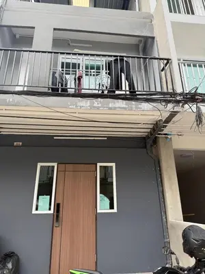 a house with a balcony with a wooden door at Best Stay 394 homestay in Phra Khanong