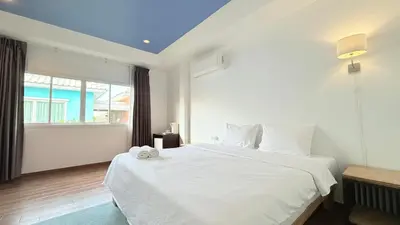 a bedroom with a white bed and a window at Issara House Bangkok in Bangkok