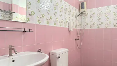 a pink bathroom with a sink and a toilet at Issara House Bangkok in Bangkok