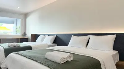 two beds in a hotel room with towels on them at Issara House Bangkok in Bangkok