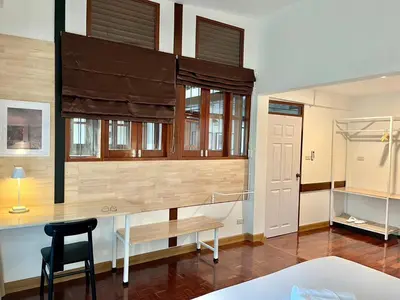 a bedroom with a desk and a chair in a room at Silpasala StayZ in Sathani Ban Hua Mak