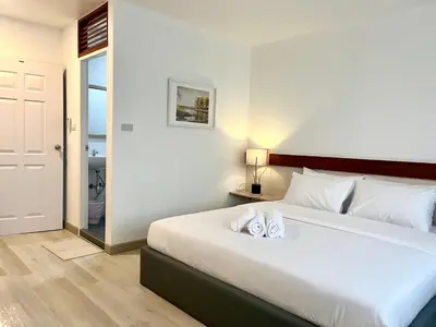 a bedroom with a large bed with two towels on it at Silpasala StayZ in Sathani Ban Hua Mak