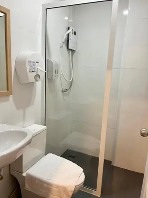 a bathroom with a shower with a toilet and a sink at Silpasala StayZ in Sathani Ban Hua Mak