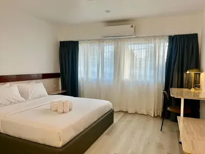 a bedroom with a bed with two candles on it at Silpasala StayZ in Sathani Ban Hua Mak