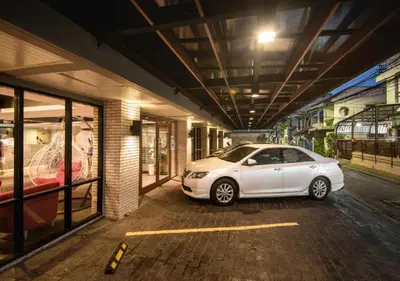 a white car parked in a parking lot at Ratchada Point Hotel in Bangkok