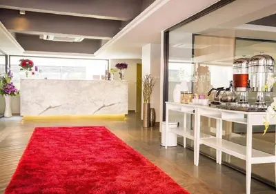 a living room with a red rug and a counter at Ratchada Point Hotel in Bangkok