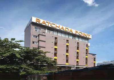 a tall building with a sign on top of it at Ratchada Point Hotel in Bangkok