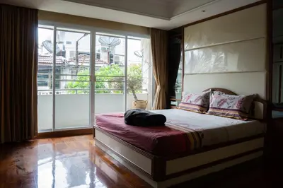 a bedroom with a bed and a large window at Modern Home in Sukhumvit in Bangkok