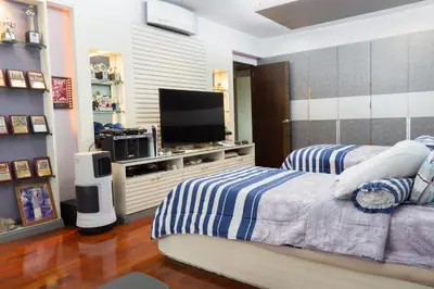 a bedroom with two beds and a flat screen tv at Modern Home in Sukhumvit in Bangkok