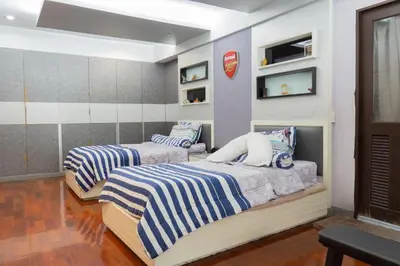 two beds in a room with blue and white stripes at Modern Home in Sukhumvit in Bangkok