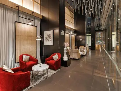 a lobby with two red chairs and a table at Spacious Serviced Apartment! in Bangkok