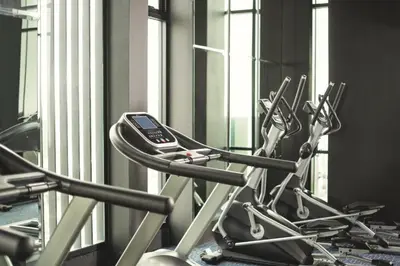 a row of exercise bikes in a gym at Spacious Serviced Apartment! in Bangkok