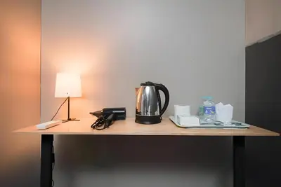 a coffee pot sitting on a table with a lamp at XX GO INN BTS Silom - Saint Louis สถานีรถไฟฟ้าเซนต์หลุยส์ in Bangkok