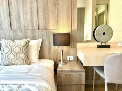 a bedroom with a bed and a desk with a lamp at Cozy & Bright apartment - Asoke in Bangkok