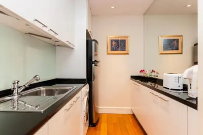 a kitchen with a sink and a refrigerator at SkyVillas Residential Apartments in Yan Nawa