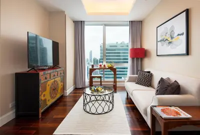 a living room with a couch and a tv at SkyVillas Residential Apartments in Yan Nawa