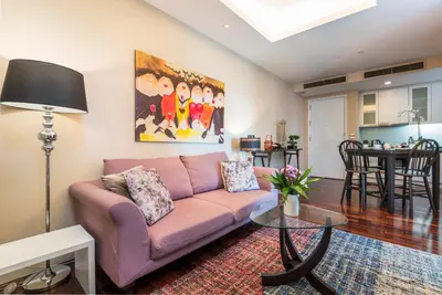a living room with a pink couch and a table at SkyVillas Residential Apartments in Yan Nawa