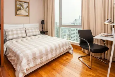 a bedroom with a bed and a desk and a window at SkyVillas Residential Apartments in Yan Nawa