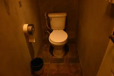 a small bathroom with a toilet in a stall at Stay At pan Hostel in Bangkok