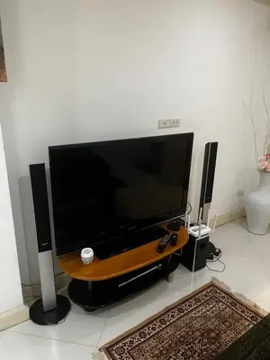 a large flat screen tv sitting on a table with speakers at Euro Classic Condominium in Bangkok