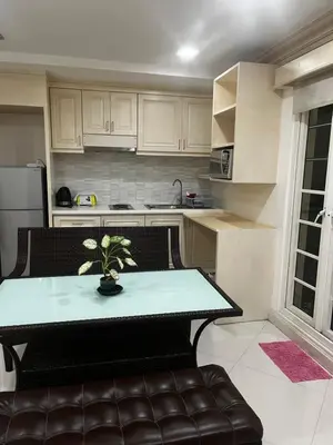 a kitchen with a table and a couch in a room at Euro Classic Condominium in Bangkok