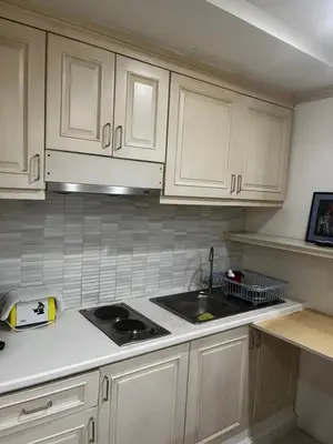 a kitchen with white cabinets and a sink at Euro Classic Condominium in Bangkok