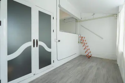 a room with a sliding glass door and a staircase at The Local Khaosan Bangkok Hotel in Bangkok