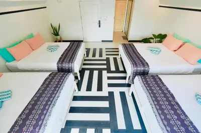 two beds in a room with striped carpet at The Local Khaosan Bangkok Hotel in Bangkok