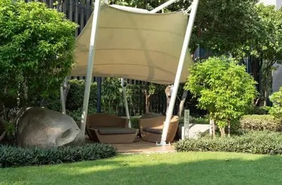 a group of chairs under a pavilion in a park at Ideo Mobi Condo in Bangkok