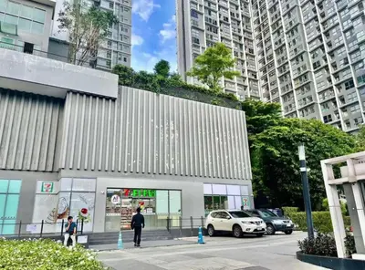 a building with cars parked in a parking lot at Ideo Mobi Condo in Bangkok