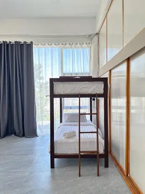 a bedroom with a bunk bed and a window at Shared Room Megun in Ban Bang Phlat