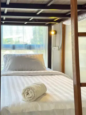 a bed with a towel on top of it at Shared Room Megun in Ban Bang Phlat