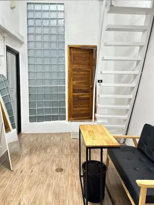 a room with stairs and a table and a door at Megun Room5 in Ban Bang Phlat