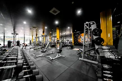 a gym with rows of equipment and people in it at River View Active 3 in Bangkok