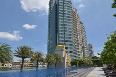 a large building with palm trees in front of it at Watermark Chaophraya River Condo in Bangkok