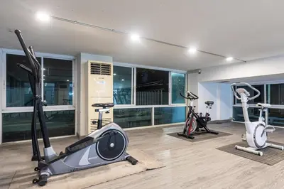 a gym with three treadmills and exercise bikes at Airbus Hotel At Phawana Station in Bangkok