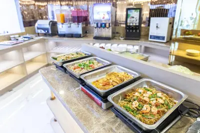 a buffet with several trays of food on a counter at Airbus Hotel At Phawana Station in Bangkok