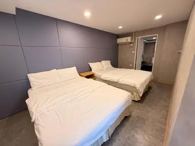 a room with two beds and a wall at Near Big Jodd Fair Night Market and Shopping Mall in Bangkok