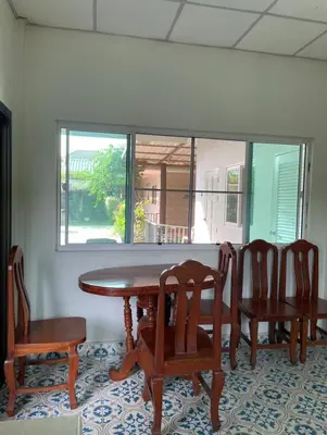 a dining room with a table and chairs and a window at J House in Nonthaburi